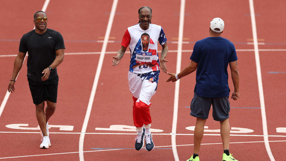 Wallace Spearmon, Snoop Dogg and Ato Boldon high-five after running on the track on during U.S. 2024 Olympic trials.