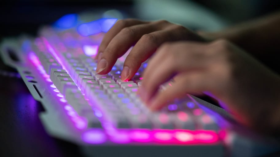 A man types on a light-up keyboard.