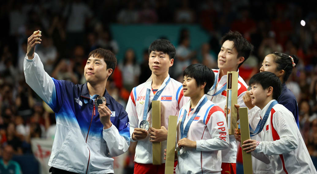 The two Korean teams and the Chinese pose for a selfie.