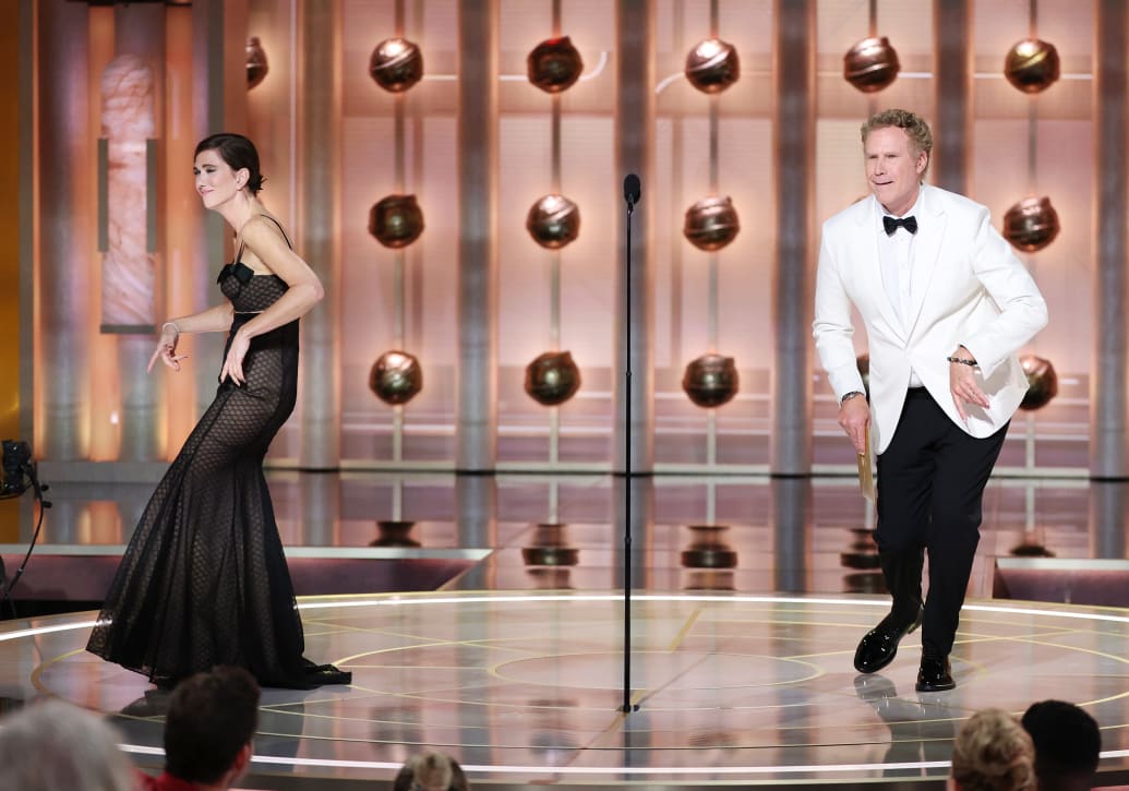 Photo of Kristen Wiig and Will Ferrell dancing while presenting the Golden Globe Awards.