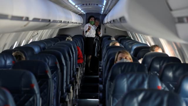 Flight attendants talk in a nearly empty cabin