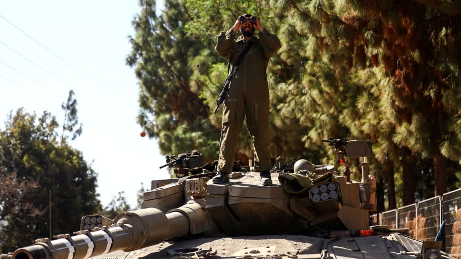 An Israeli soldier stands on a tank at Israel's border with Lebanon