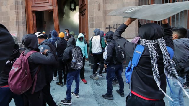 Students demonstrate after breaking down a presidential palace door in Mexico City.