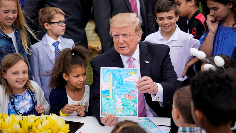 U.S. President Donald Trump shows off a card made for military members, during the 2019 White House Easter Egg Roll.