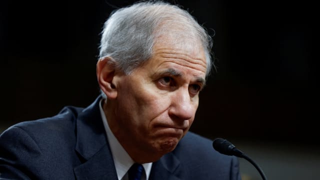 Martin Gruenberg frowns while being questions by lawmakers.
