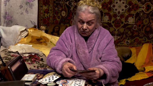 Anastasia predicting the future of the war in Ukraine with her playing cards and psychic abilities in her bedroom in eastern Ukraine.