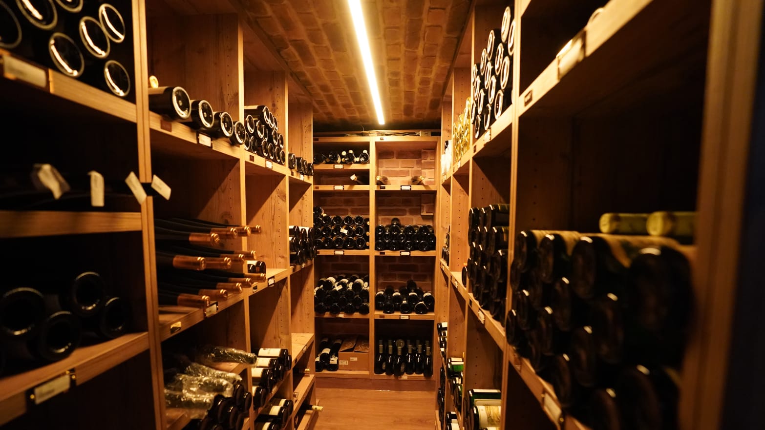 Bottles of red wine lie on shelves in the wine cellar of a luxury hotel.