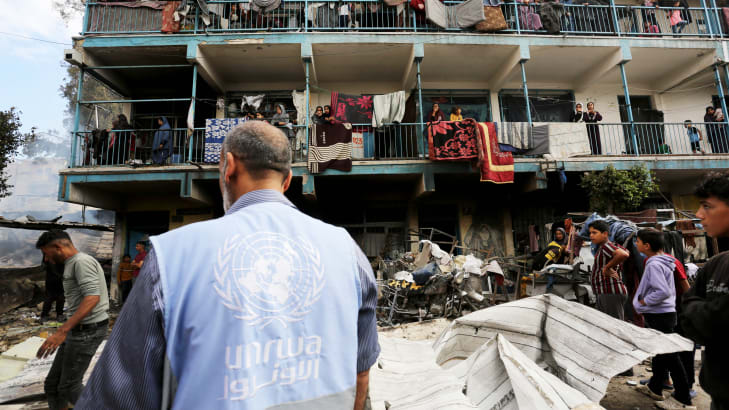 An UNRWA employee looks on at Palestinians in a school attacked by Israeli forces in Gaza on May 14, 2024.