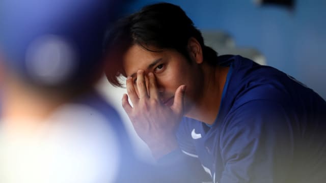 Shohei Ohtani stares to his right inside the Los Angeles Dodgers dugout.