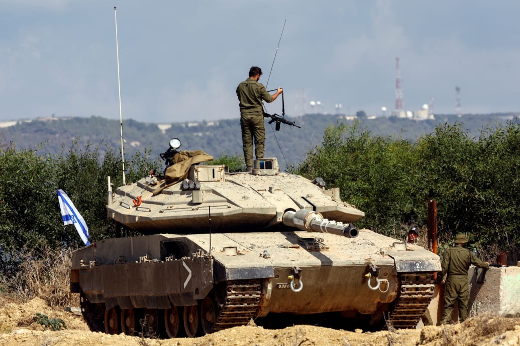 A photo including an Israeli soldier near Israel's border in Lebanon in Northern Israel