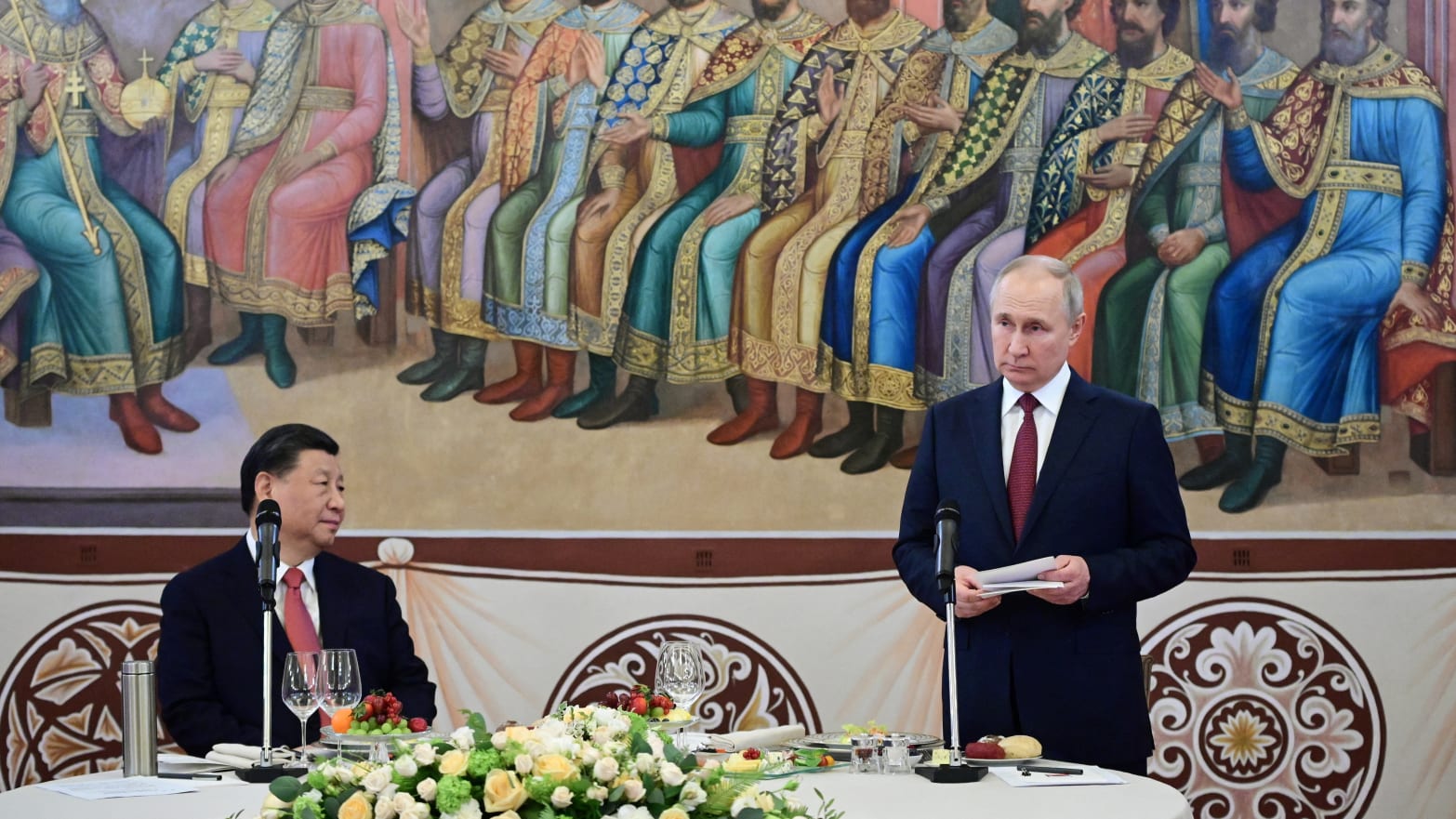 Chinese President Xi Jinping watches as Russian President Vladimir Putin speaks at a reception.