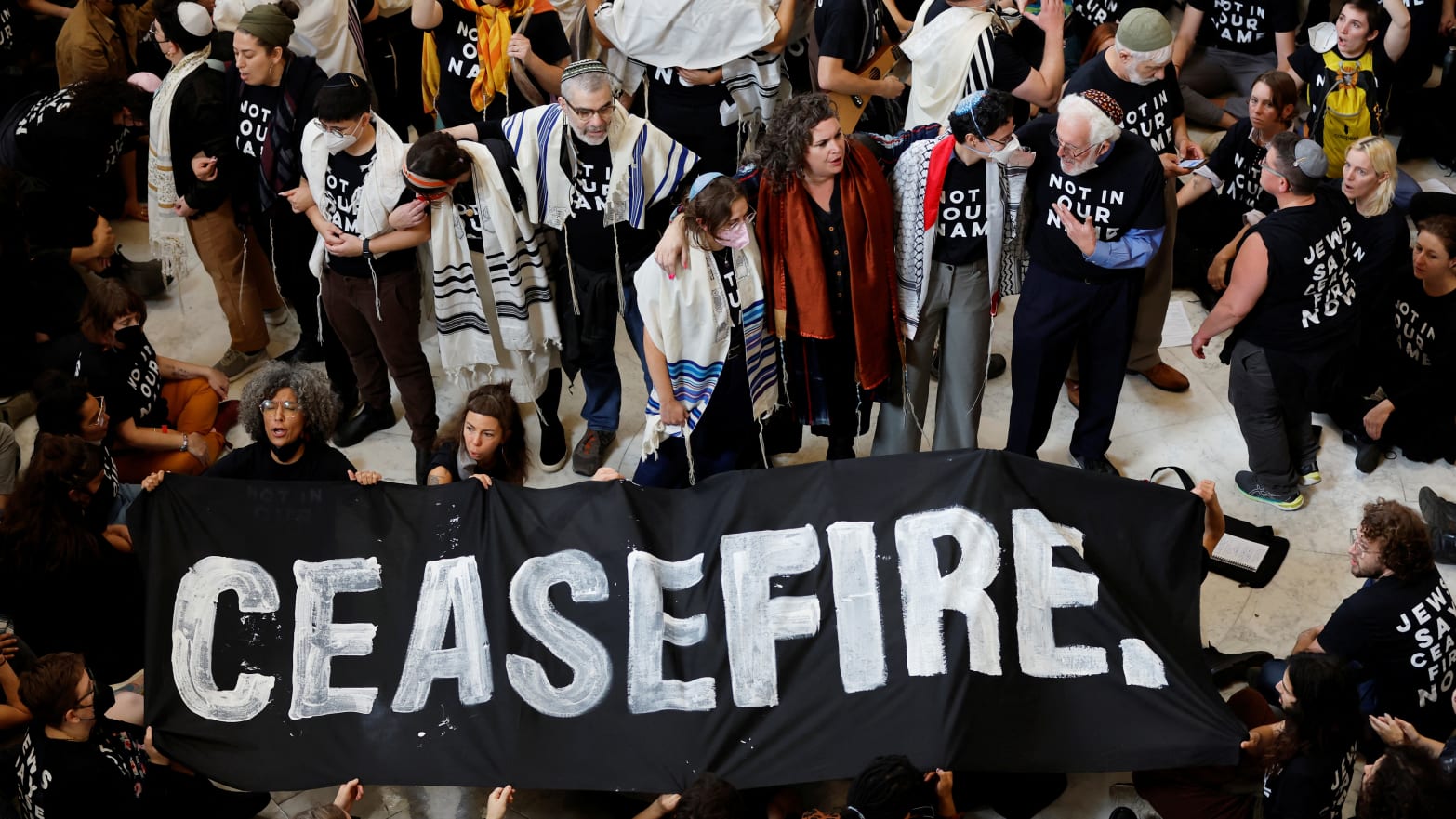 A photo of protesters calling for a cease fire in Gaza and an end to the Israel-Hamas conflict as they occupied the rotunda of the Cannon House office building with a banner reading: “CEASEFIRE.”