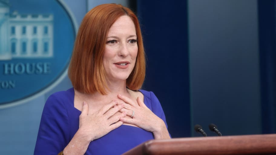 Jen Psaki holds her hands to her chest during a press briefing.