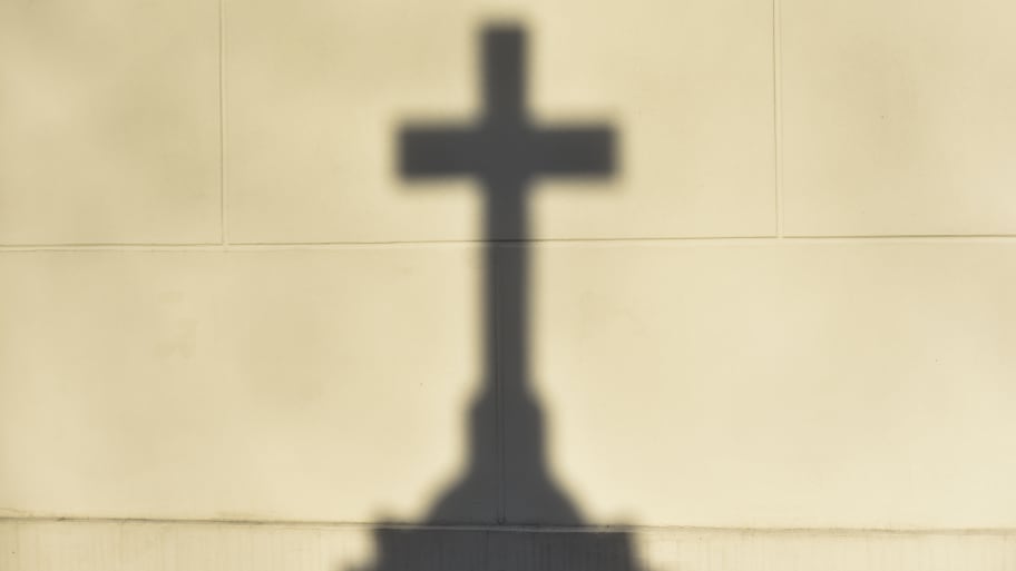 The shadow of the Christian cross on the wall.