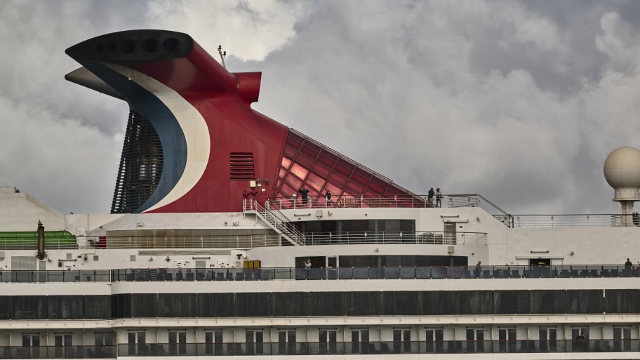 Passengers are seen on the upper deck as Carnival Pride, a Spirit-class cruise ship operated by Carnival Cruise Line, sails the Tagus River after leaving the Cruise Terminal on June 01, 2022 in Lisbon, Portugal.