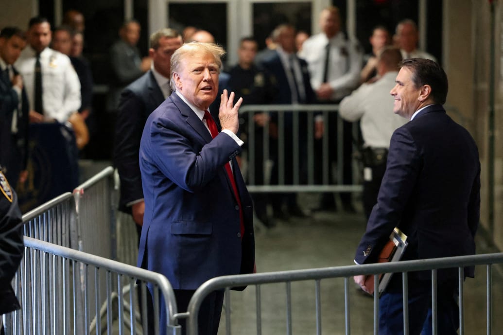 Former President Donald Trump gestures outside the courtroom on the day of a court hearing on charges of falsifying business records to cover up a hush money payment to a porn star before the 2016 election