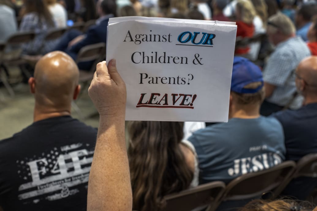 A person holds a sign in support of Chino Valley school board’s policy to require schools to ‘out’ students to parents if they ask to be identified by a gender not listed on their birth certificate. 