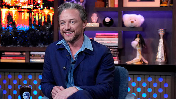 James McAvoy, in a blue suit, smiles on set of Watch What Happens Live.