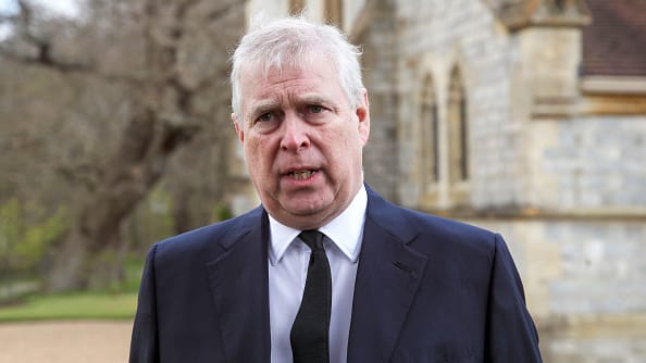 Prince Andrew speaks with reporters outside a church in England.