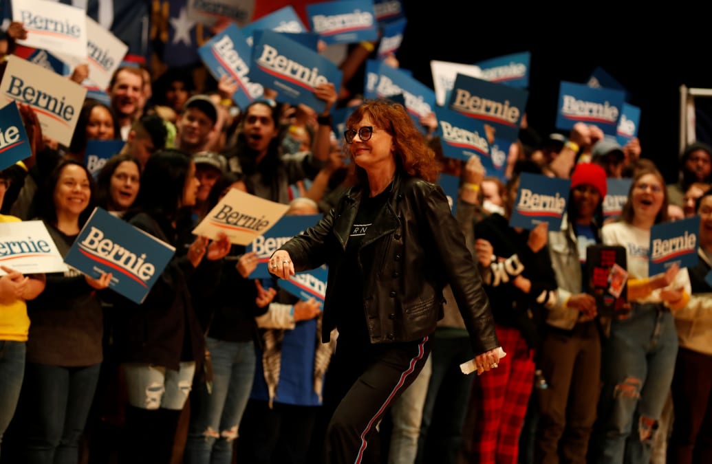 Actress Susan Sarandon walks off a stage surrounded by supporters of Sen. Bernie Sanders.
