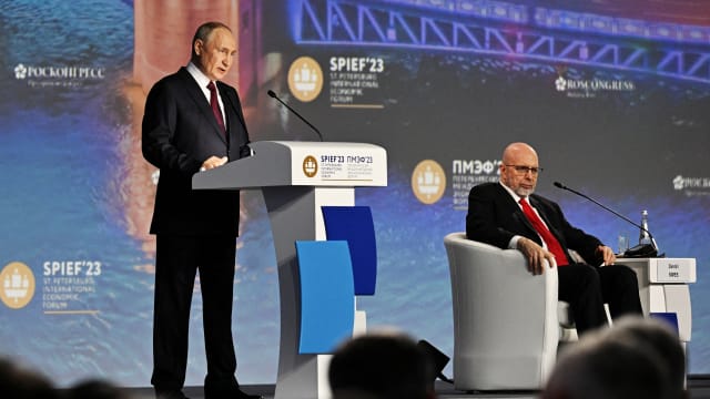 Russian President Vladimir Putin and moderator Dimitri Simes attend a session of the St. Petersburg International Economic Forum (SPIEF).