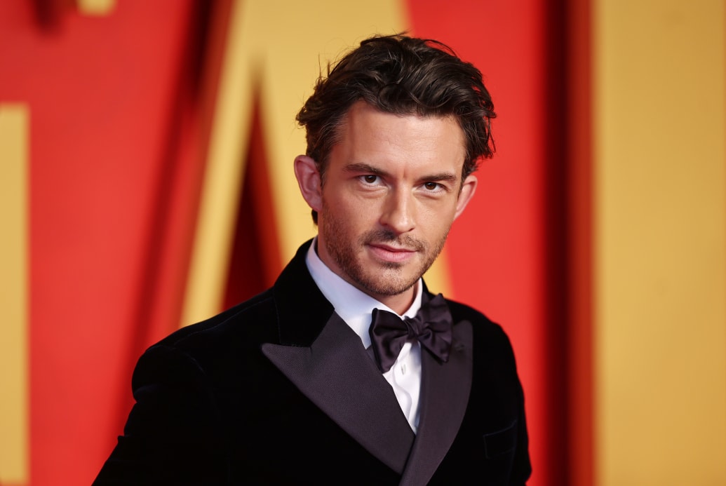 A photo of Jonathan Bailey on a red carpet.