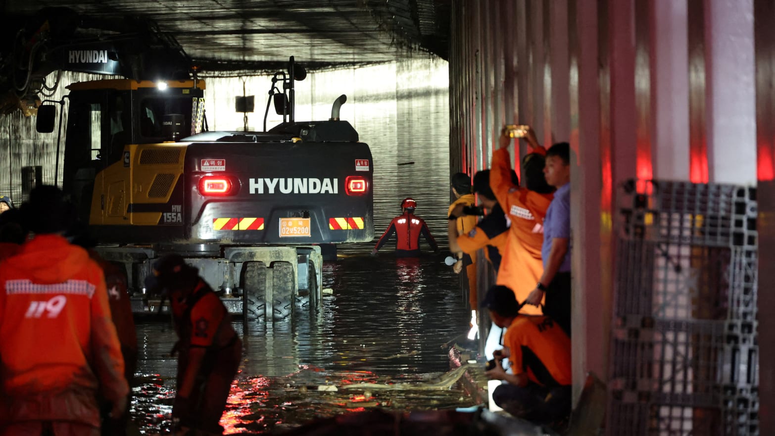 Rescue teams work at a flooded tunnel in Cheongju, South Korea, where at least 13 people died after becoming trapped by flooding.