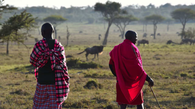A photograph of two  Maasai guides leading a walking safari in Kenya.