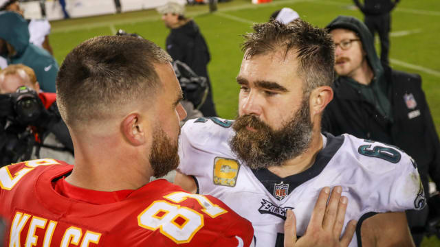 Philadelphia Eagles center Jason Kelce and Kansas City Chiefs tight end Travis Kelce hug after an NFL football game.