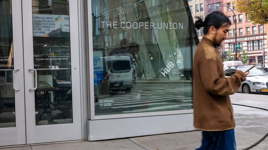 People walk outside of one of the buildings at Cooper Union