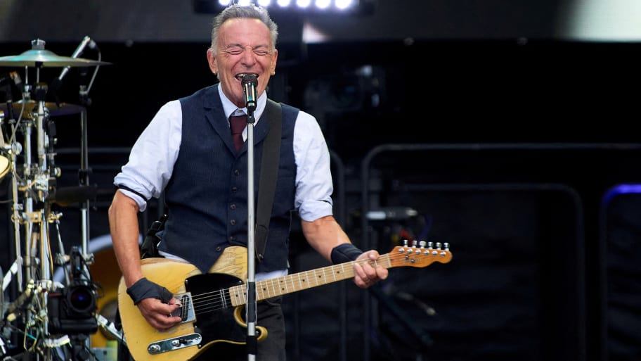 Bruce Springsteen sings and plays guitar on stage