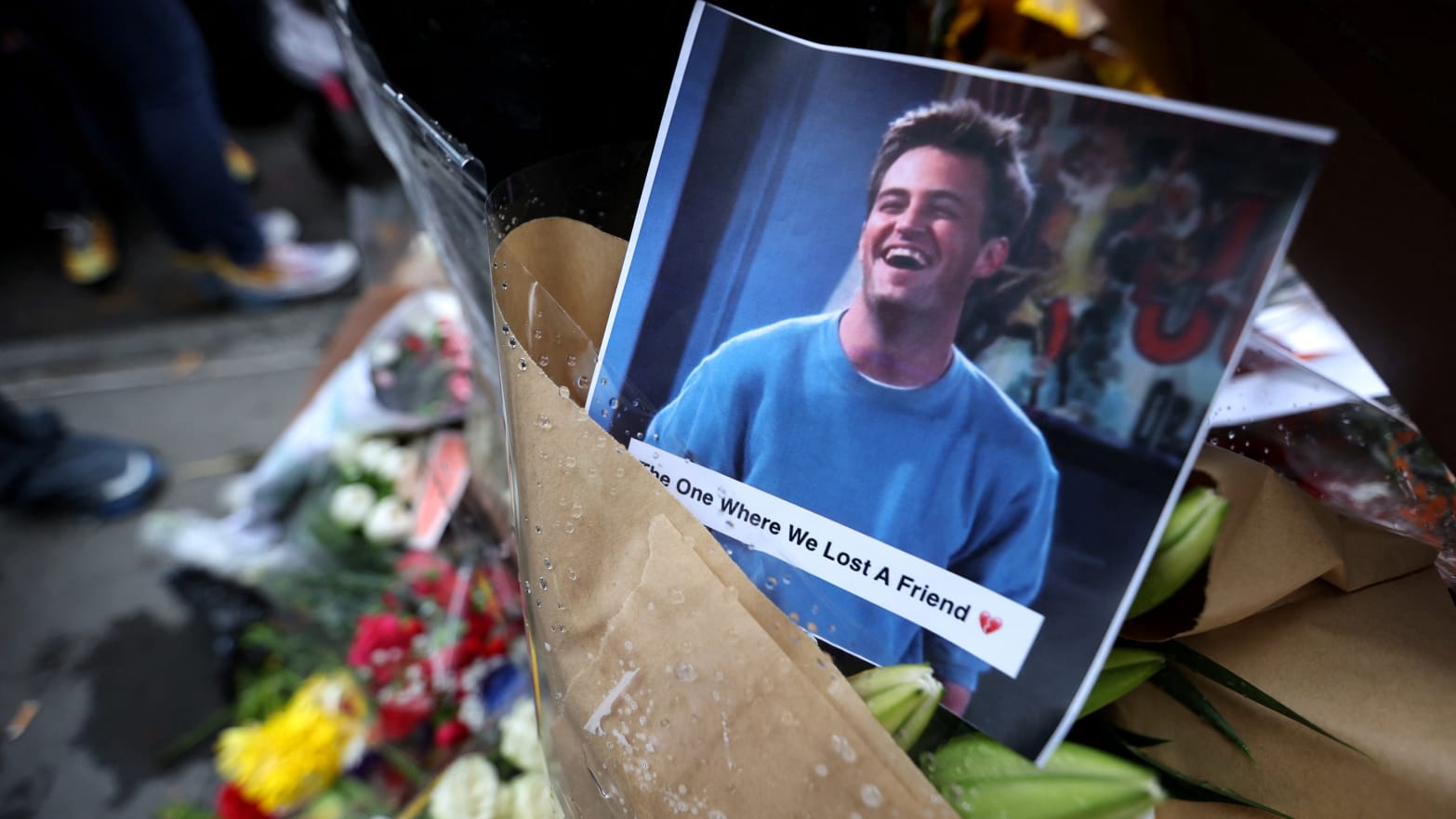 A memorial with flowers and a photo of the late actor Matthew Perry.