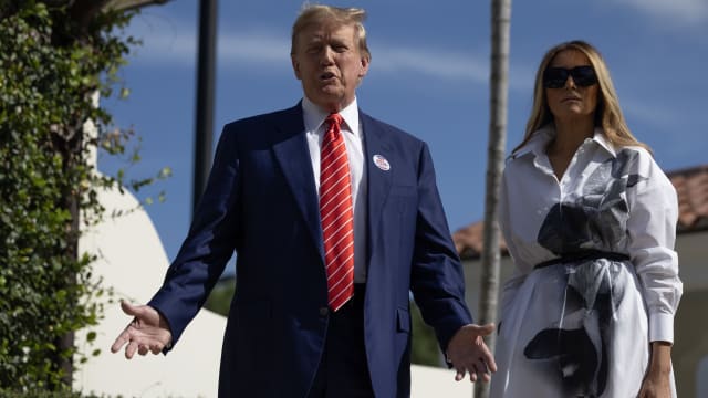 Former U.S. President Donald Trump and former first lady Melania Trump stand together as they speak with the media after voting at a polling station setup in the Morton and Barbara Mandel Recreation Center on March 19, 2024, in Palm Beach, Florida.   