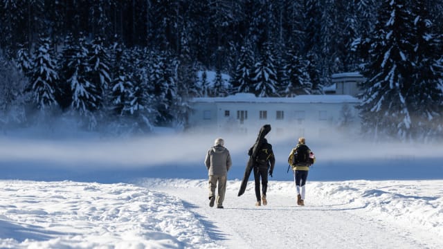 Switzerland, Davos: People walking along a ski slope.