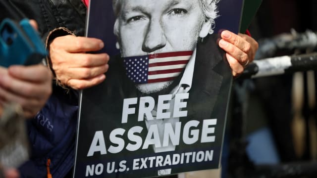 A demonstrator holds a sign that reads “FREE ASSANGE” and “NO U.S. EXTRADITION.”