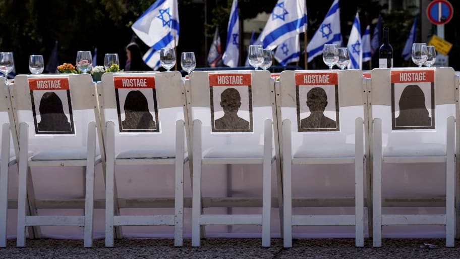 A dinner table is set with empty chairs that symbolically represent hostages and missing people with families that are waiting for them to come home, in Tel Aviv, Israel, Oct. 20, 2023.
