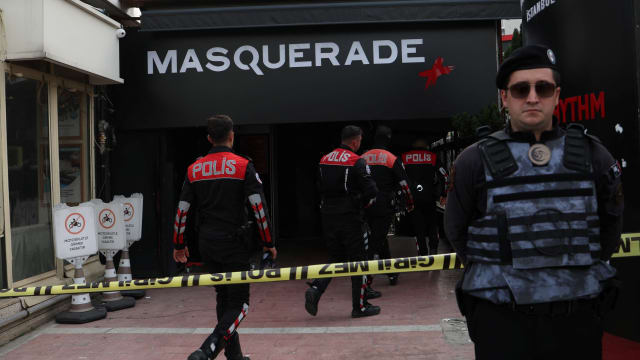 An officer stands in front of the Masquerade nightclub where dozens died Tuesday.