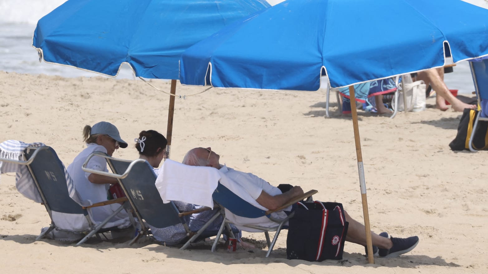 US President Joe Biden (C) relaxes at the beach with First Lady Jill Biden (L) and granddaughter Naomi (2nd L)