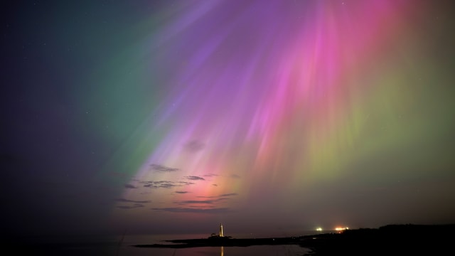 The aurora borealis, also known as the northern lights, glow on the horizon at St Mary's Lighthouse in Whitley Bay on the North East coast of England.