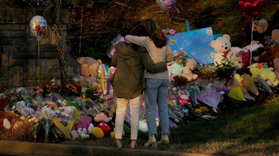 Community members embrace while visiting a memorial at the school entrance after a deadly shooting at the Covenant School in Nashville, Tennessee, March 29, 2023. 