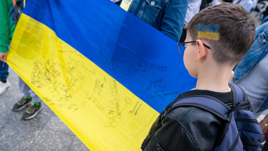 A boy with the flag of Ukraine painted on his hair holds the flag of Ukraine during an action in support of prisoners of war on May 20, 2023 in Lviv, Ukraine. 