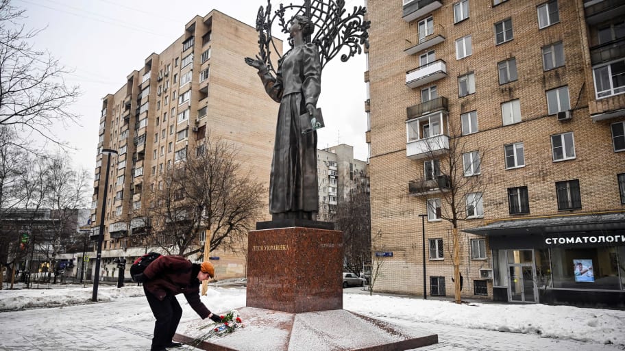 A man lays flowers in memory of those killed in a recent strike on a residential block in the Ukrainian city of Dnipro, at the monument to Ukrainian poetess Lesya Ukrainka in Moscow on Jan. 23, 2023.