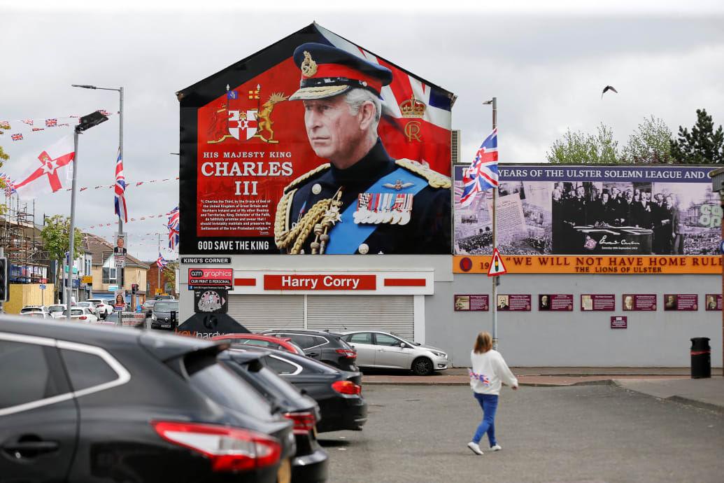 A person walks near a mural of Britain's King Charles on the side of a building, on the day of King Charles and Queen Camilla's coronation, in west Belfast, Northern Ireland May 6, 2023.