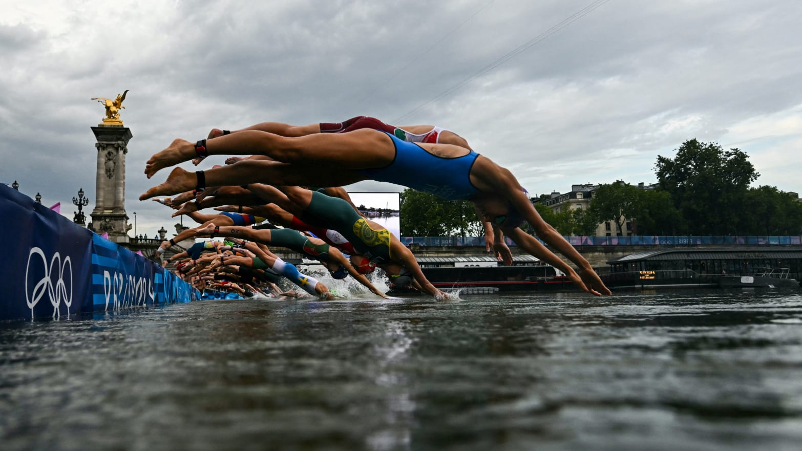 The women dive into the Seine at the start of the triathlon