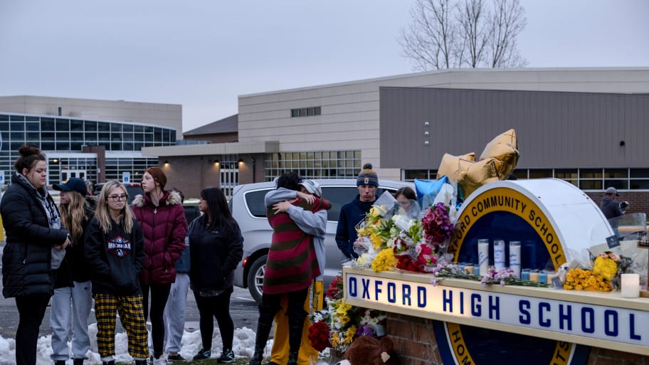 Students gather around a memorial at Oxford High School after the 2021 shooting.