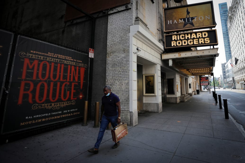 A man walks past the shuttered Richard Rodgers Theatre, home of the popular musical "Hamilton" after industry group the Broadway League said Broadway theaters will remain closed through January 3, 2021, in New York, U.S., July 2, 2020.