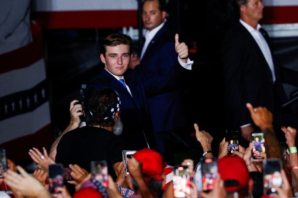 Barron Trump gives a thumbs up at a campaign rally at Donald Trump's golf resort in Doral, Florida