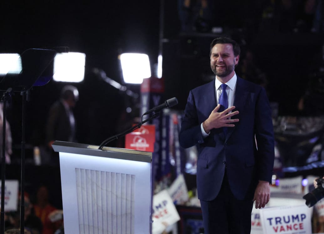 J.D. Vance on stage, hand on heart, smiling