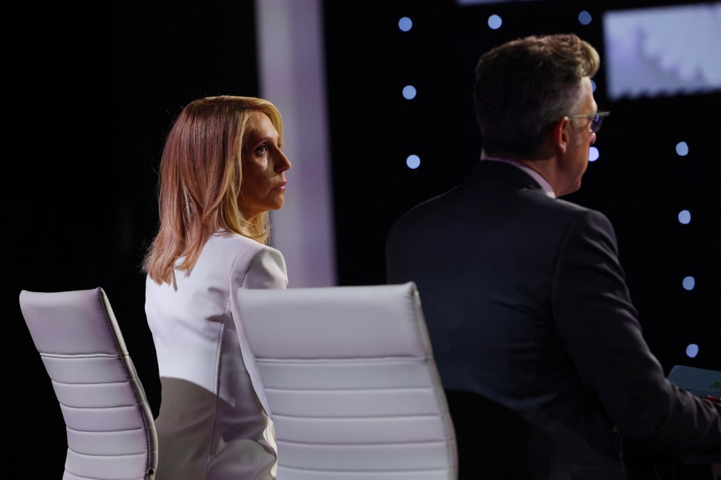 Dana Bash stares forward at a desk next to Jake Tapper