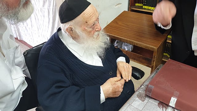 Rabbi Chaim Kanievsky sits at a desk.